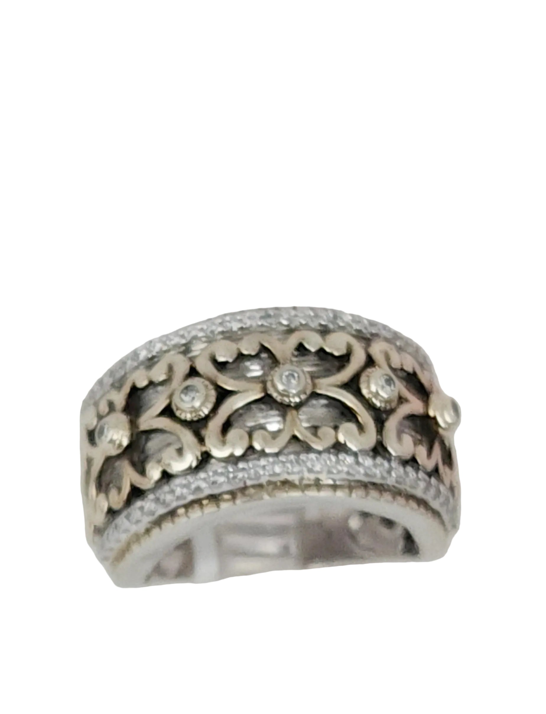 A Sterling Silver and Vermeil estate ring with a wide band and adorned with Cubic Zirconia, displayed on a clear surface.