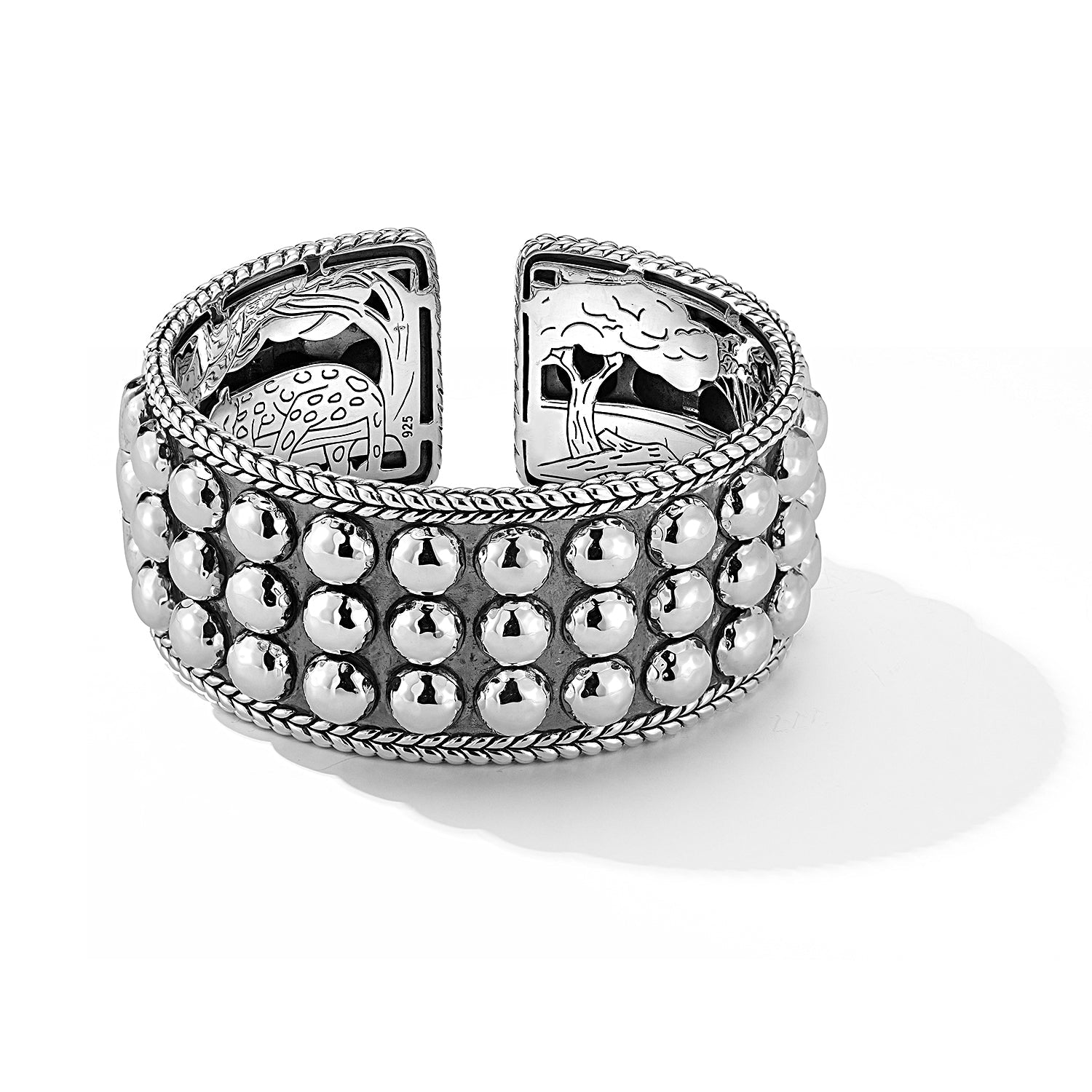 Our Sterling Silver Hammered Dot Hinged Cuff Bangle features three full rows of Hammered design elements and is finished with Basketweave edges and our signature inner carved art work. Cuff opening is